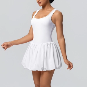 Detailed view of white sleeveless athletic dress featuring a pleated bubble skirt hemline