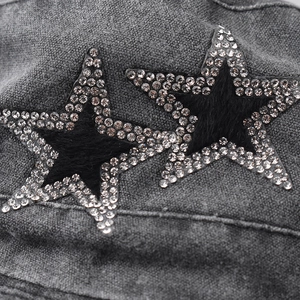 Macro detail of two rhinestone star patches on washed grey cotton outdoor sun hat