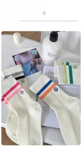 Detail showing colorful striped knit socks with smiling face embroidery in a cozy setting