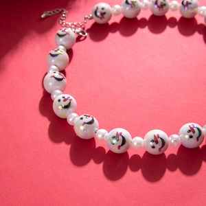 Acrylic snowman beaded necklace with faux pearls on red festive background