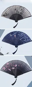 Detailed close-up of three decorative Chinese folding fans with floral patterns and tassels
