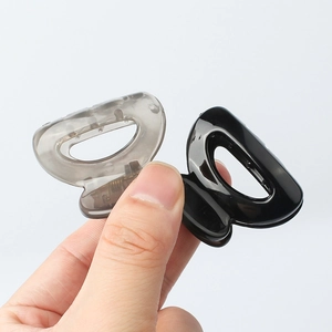 Mini matte hollow semi-circle hair claws in grey and black held between fingers