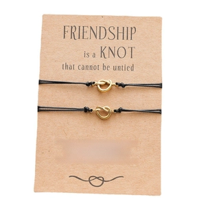Detail of friendship knot bracelets on card with message Friendship Is A Knot