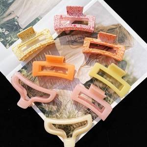 Matte and marble acrylic geometric hair claws in pink, orange, and beige colors