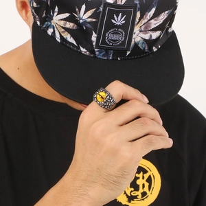 Detail of punk ring with dragon eye stone and skeleton motifs on model's hand