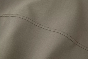 Close-up of double-needle stitching and high-quality khaki woven fabric on bomber jacket
