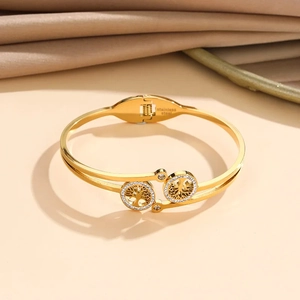 Macro view of golden tree of life bangle with crystal inlay and stainless steel engraving