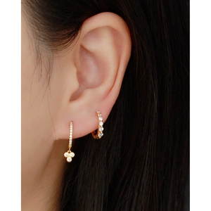Detailed shot of S925 silver gold clover earrings and cubic zirconia hoop earrings