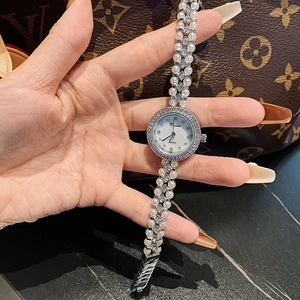 Close-up of pearl bracelet watch with diamond-encrusted bezel on a woman's wrist