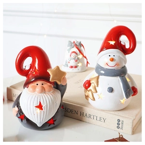 Close-up of ceramic Christmas Santa and snowman ornaments with warm LED glowing lights