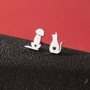 Macro shot of asymmetrical silver cat and dog stud earrings with heart cutouts