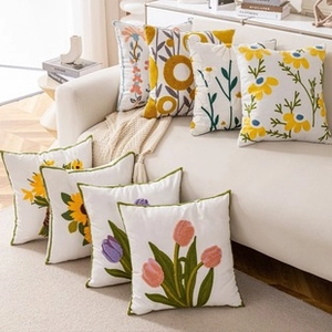 Close-up of floral embroidery patterns on luxury white cotton-linen cushion covers