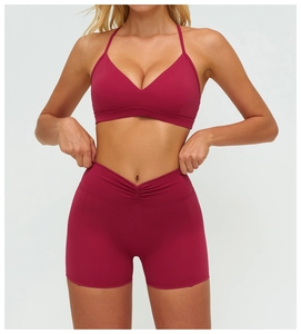 Détail macro de la taille haute croisée en V sur ce short de sport de couleur magenta