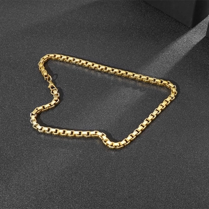 Detailed view of a 7mm gold-plated stainless steel box chain necklace on black background