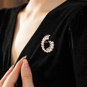 Detailed close-up of pearl and zircon brooch pinned on elegant black velvet fabric