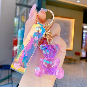 Purple geometric crystal bear keychain with iridescent strap and gold metal clasp