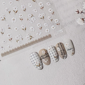 Detailed 3D embossed nail art stickers featuring white daisies and lace floral designs