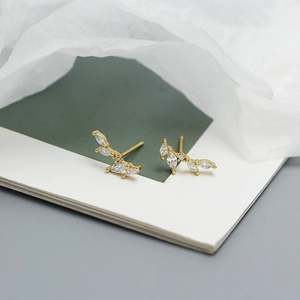Detailed view of gold leaf olive branch stud earrings with sparkling zircon crystals
