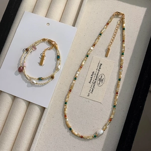 Macro shot of double-layer freshwater pearl bracelet with gold-plated clasp and colorful beads