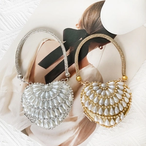 Close-up of heart-shaped mini bags with luxury rhinestones and pearls in gold and silver