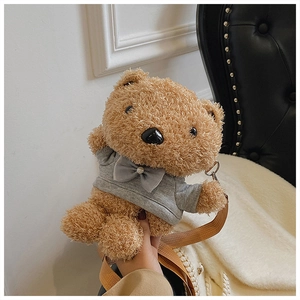 Detailed close-up of a brown plush teddy bear crossbody bag with a grey bow tie sweater