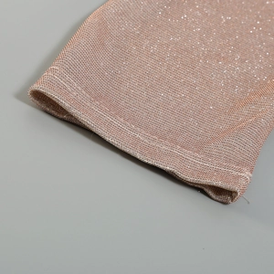 Macro shot of rose gold metallic knit fabric showing the fine sparkling texture and weave