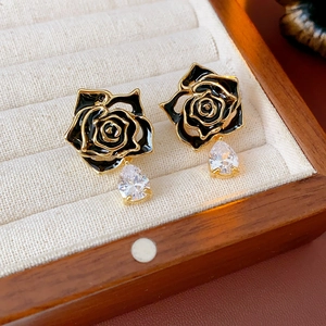 Détail de boucles d'oreilles fleur vintage avec émail noir et goutte de zircon poire