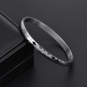 Macro view of hammered texture on stainless steel bangle with hidden clasp