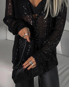 Gros plan du tissu d'une chemise à paillettes noires montrant la texture scintillante