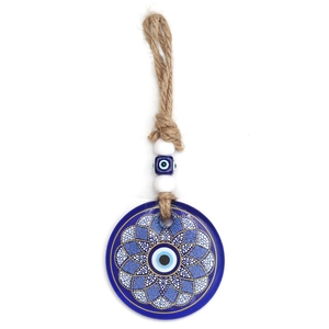 Close-up of glass evil eye pendant with blue beads and natural jute rope on white background