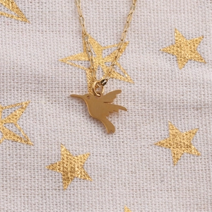 Elegante collana con ciondolo a colibrì dorato in acciaio al titanio su sfondo stellato