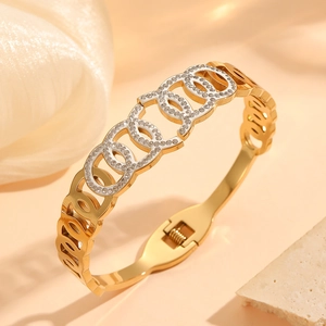 Golden titanium steel bangle featuring cross pattern and diamond inlay on stone texture