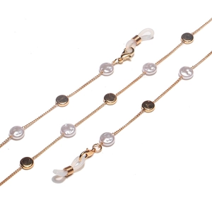 Detail of gold metal eyewear chain with white pearls and anti-slip rubber loops