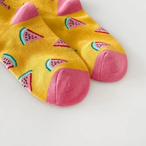 Detail view of yellow cotton blend socks with pink and blue watermelon pattern design