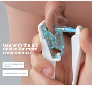 Detail showing white piercing gun with light blue components used on a silicone ear model