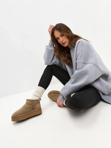 Detail view of chestnut brown suede snow boots with thick anti-slip rubber soles
