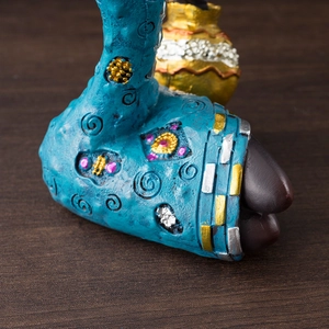 Macro detail of resin figurine with blue, gold and pink hand-painted embossed textures