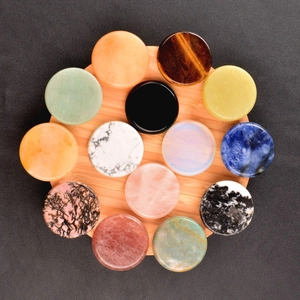 Detailed top view of various colorful polished natural stone disks on a wooden tray