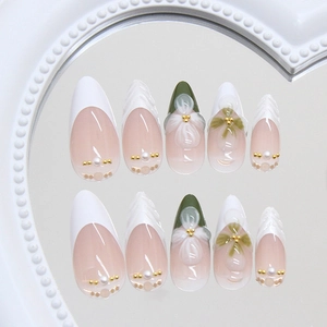 French almond press-on nails with white tips, green wave patterns and 3D floral accents