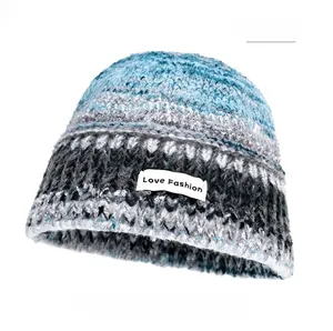 Detail of coarse knit winter bucket hat with blue and gray gradient texture and patch