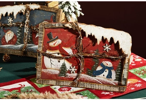Detail of rustic Christmas tabletop plaques featuring snowman and Santa with faux snow decor