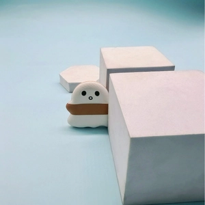 Cute ghost-shaped white marshmallow air cushion puff on light blue geometric background