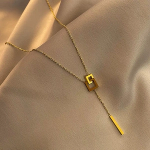 Minimalist double interlocking ring necklace with a long tassel on beige silk fabric