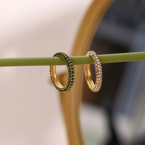 Macro view of gold plated eternity rings featuring green and clear zircon stones