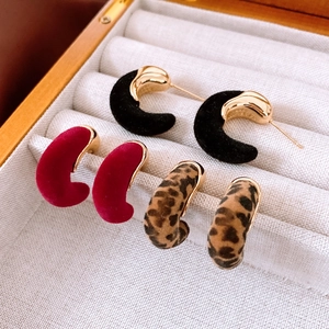 Vue détaillée de trois paires de boucles d'oreilles en forme de C en velours noir, rouge et léopard
