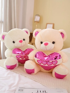 Detail of plush teddy bears with pink glossy love hearts and embroidered love lettering