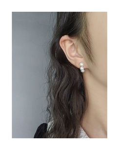 Détail de boucles d'oreilles en argent S925 avec trois perles blanches verticales