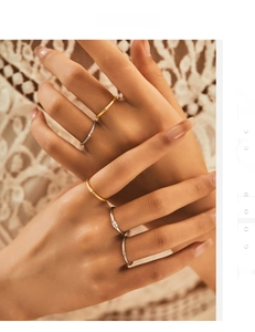 Close-up of minimalist stacked rings with sparkling zircons and delicate lace background