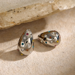 Silver teardrop stud earrings with multicolored rhinestones on a natural stone background