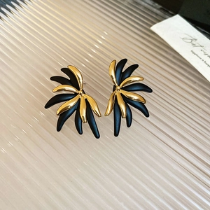 Detail of 18k gold plated flower earrings with black and gold matte radial design
